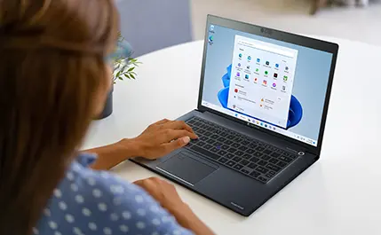 A woman using a Dynabook Laptop to access programs for work