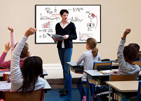 a classroom of young children and teacher with a display on the wall