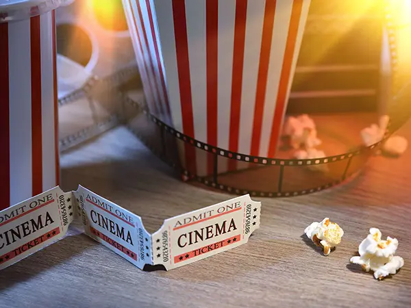 Movie tickets, a film strip, and popcorn