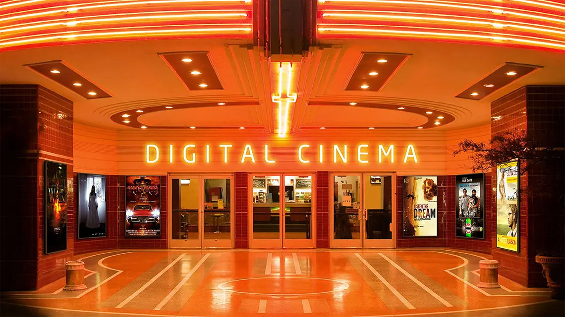 The entrance to a cinema with neon signage saying 'DIGITAL CINEMA'