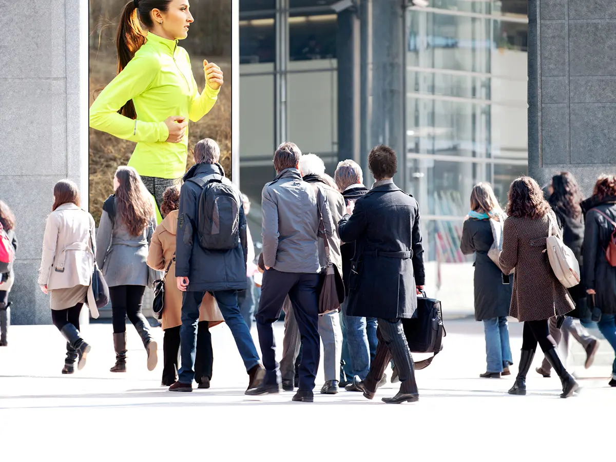 People walking past a vertical LED display outside