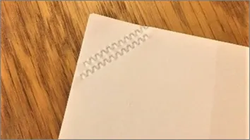 Image of paper with crimped corners using stapleless printing instead of staples