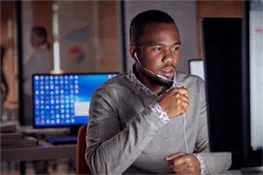 Man and woman working on a laptop in a room filled with multiple servers