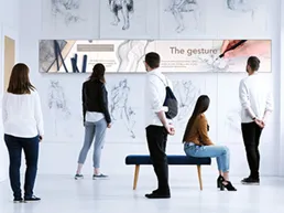 People in a museum looking at art on a digital sign