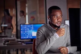 Man working on a computer with another monitor in the background