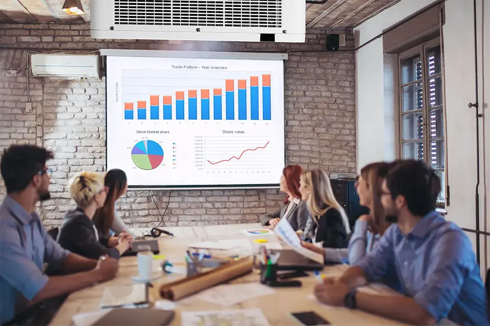 Laser projector ceiling mounted in conference room projecting presentation slides 