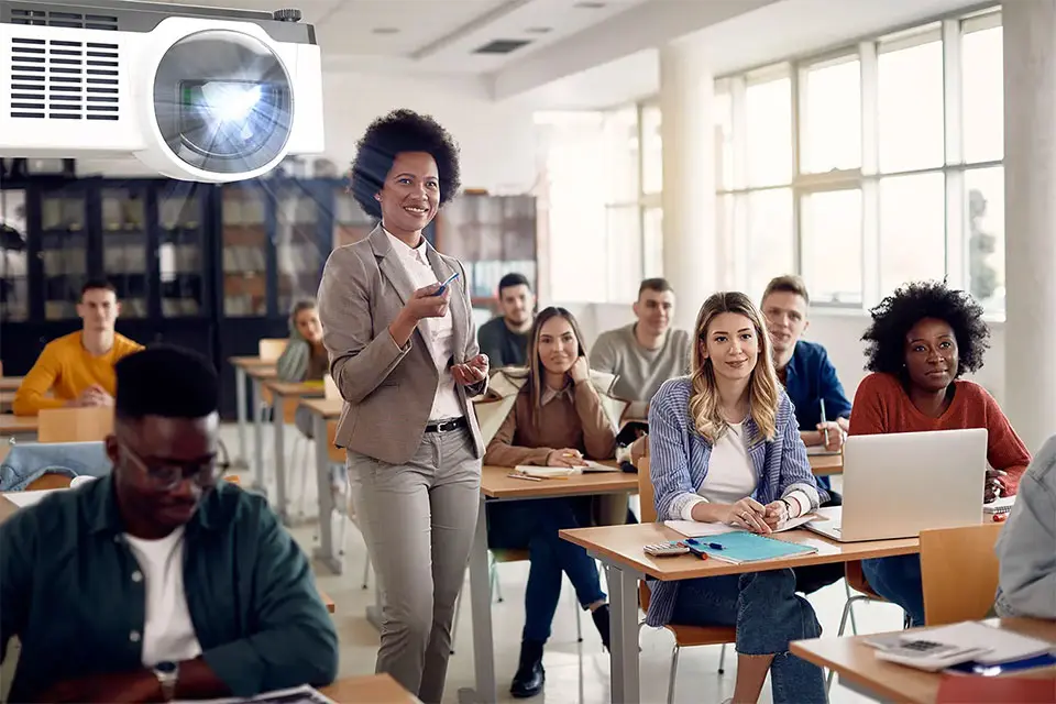 Laser projector mounted on the ceiling projecting content in classroom full of students