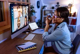 Man on cell phone standing in front of a monitor