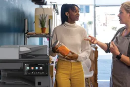 Two Women standing in front of a copier