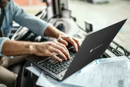 Close up of a man typing on a Dynabook laptop