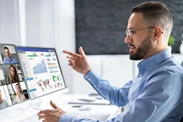 Man sitting in front of a bank of monitor screens